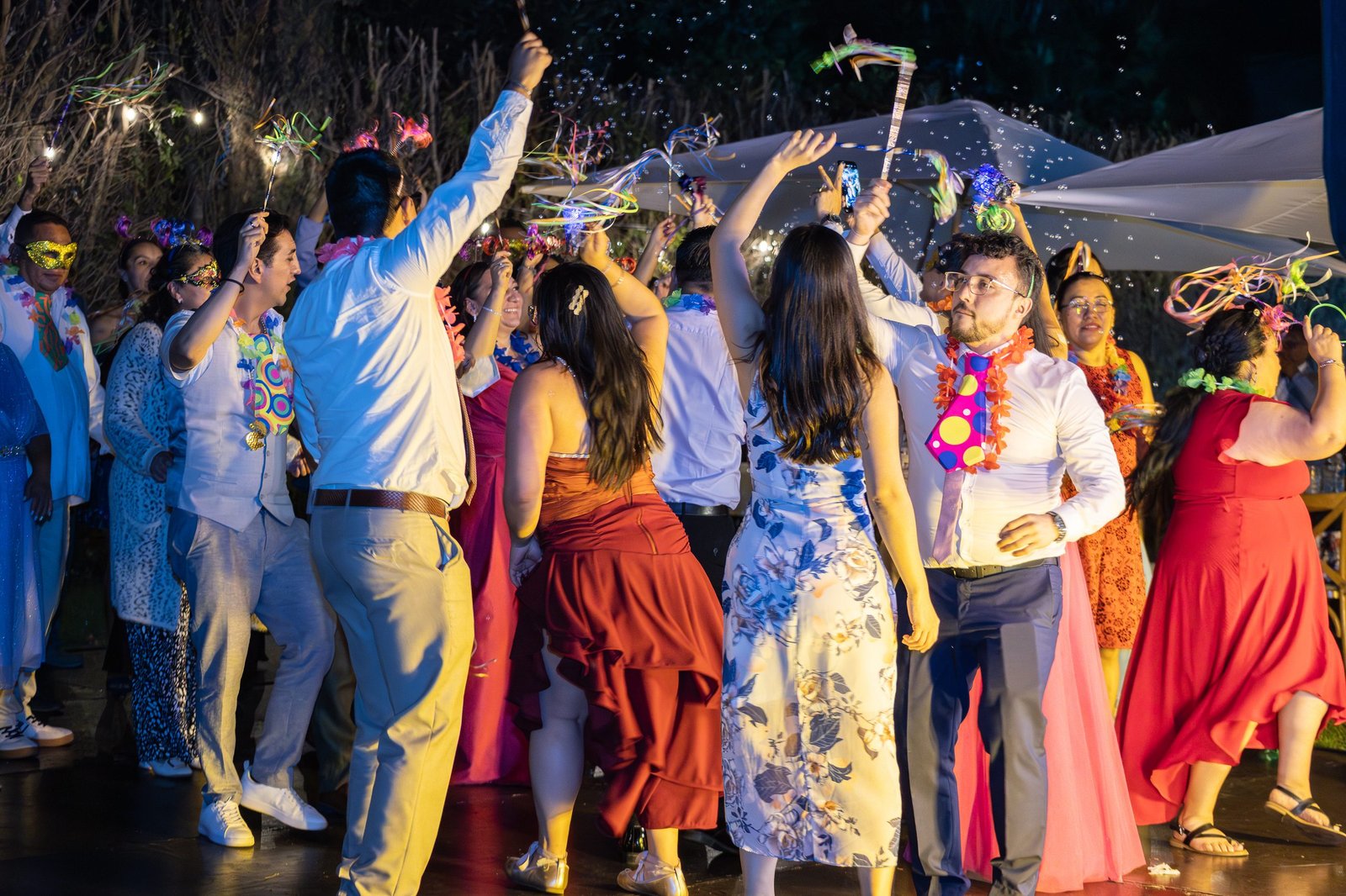 Invitados bailando con listones y burbujas en plena fiesta